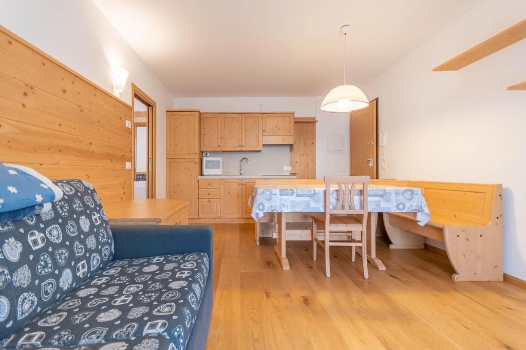 ein Wohnzimmer mit einem blauen Sofa und einem Tisch in der Unterkunft Casa Pecol in Falcade
