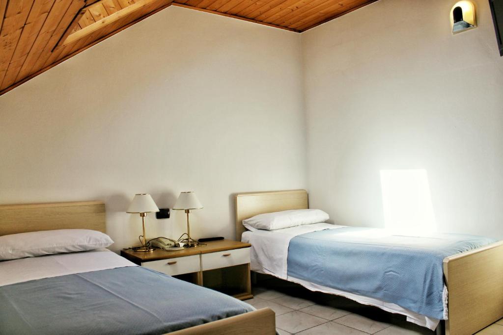 sypialnia z 2 łóżkami i stołem z lampkami w obiekcie Albergo Hofer w mieście Bolzano