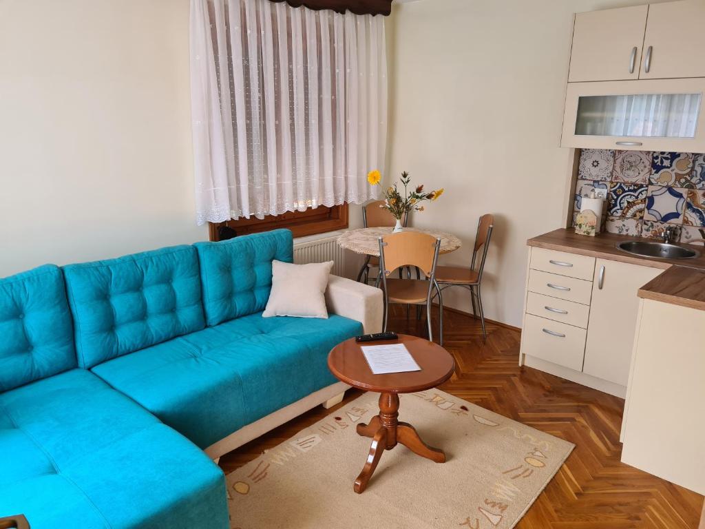 sala de estar con sofá azul y mesa en Apartman Bubamara, en Arilje