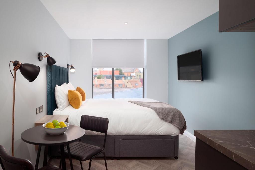 a bedroom with a bed and a table with a bowl of fruit at Aptel East in London