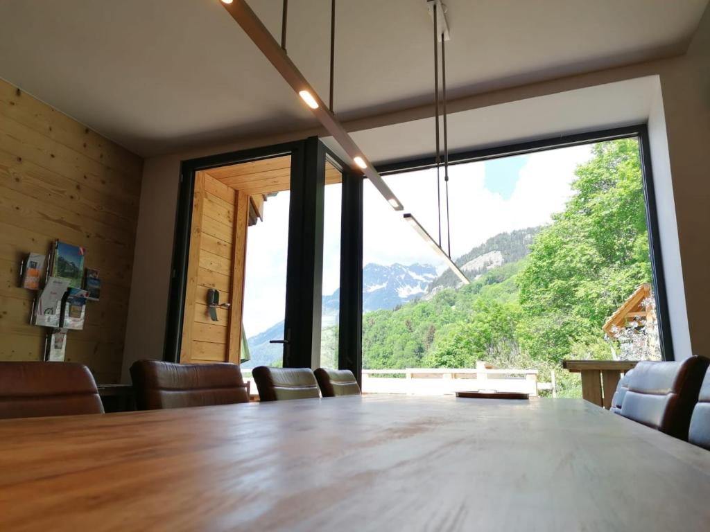 une salle à manger avec une table et une grande fenêtre dans l&#39;établissement Chalet Le Petit Plus, à Vaujany