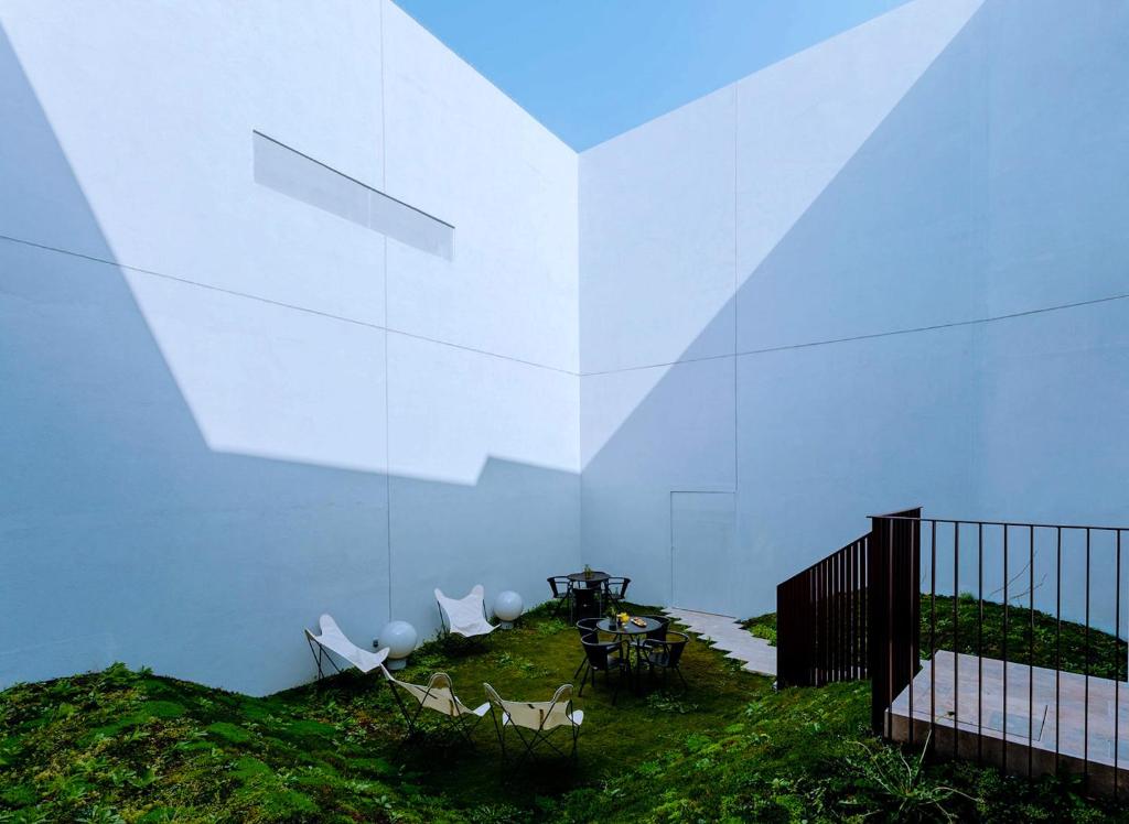 a white building with chairs and a table and a fence at THE MODERNIST, Architecture experience in Faro