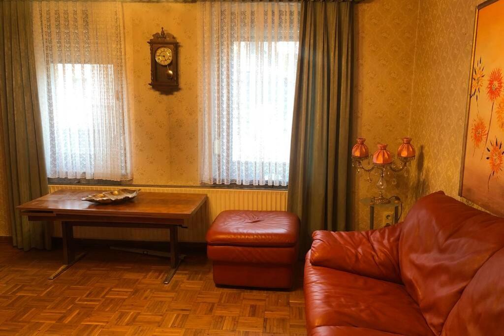 ein Wohnzimmer mit einem Sofa, einem Tisch und einer Uhr in der Unterkunft Ahmed Al-Hamadani in Verden