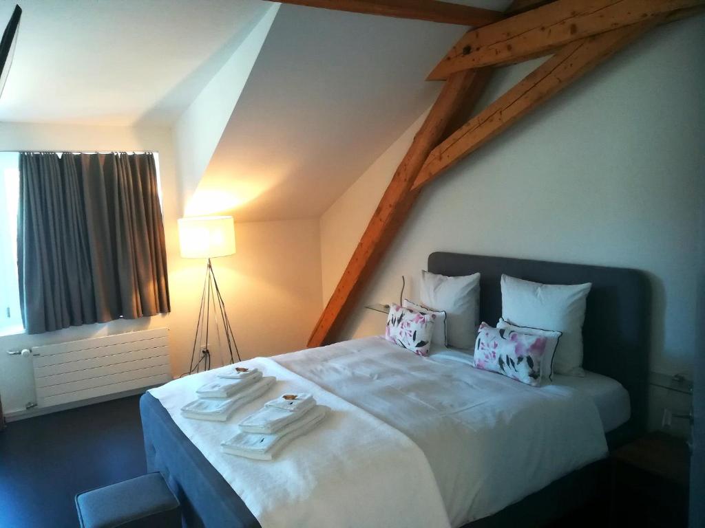 a bedroom with a large white bed with pillows at Relais du Simplon in Conthey