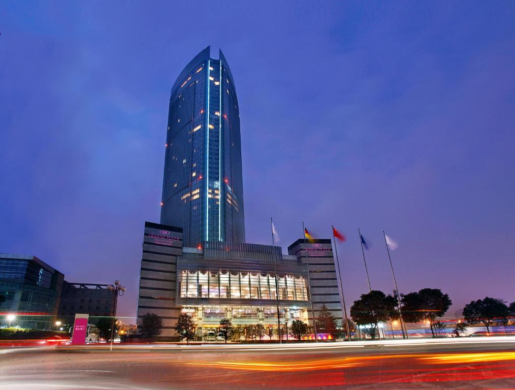 wysoki budynek z mnóstwem świateł w obiekcie Crowne Plaza Wuxi City Center w mieście Wuxi