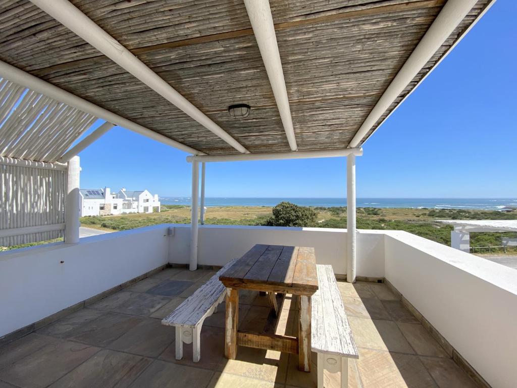 a wooden table on the balcony of a house at Induku in Paternoster