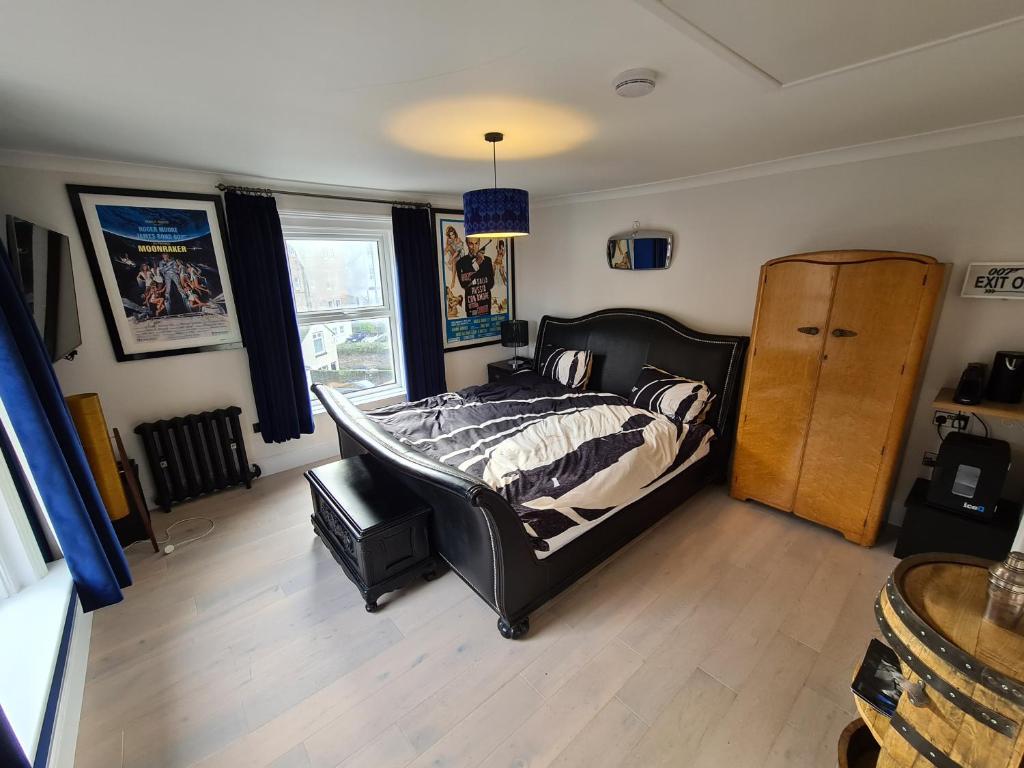 1 dormitorio con 1 cama y suelo de madera en Southsea Royale Studio, James Bond, Parking, Seafront, en Portsmouth