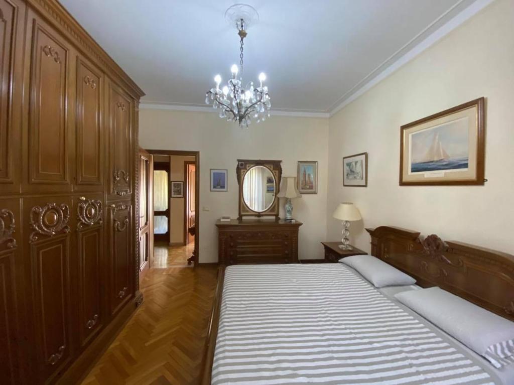 Casa Vacanze Rosignoli في كريمونا: غرفة نوم بسرير كبير وثريا