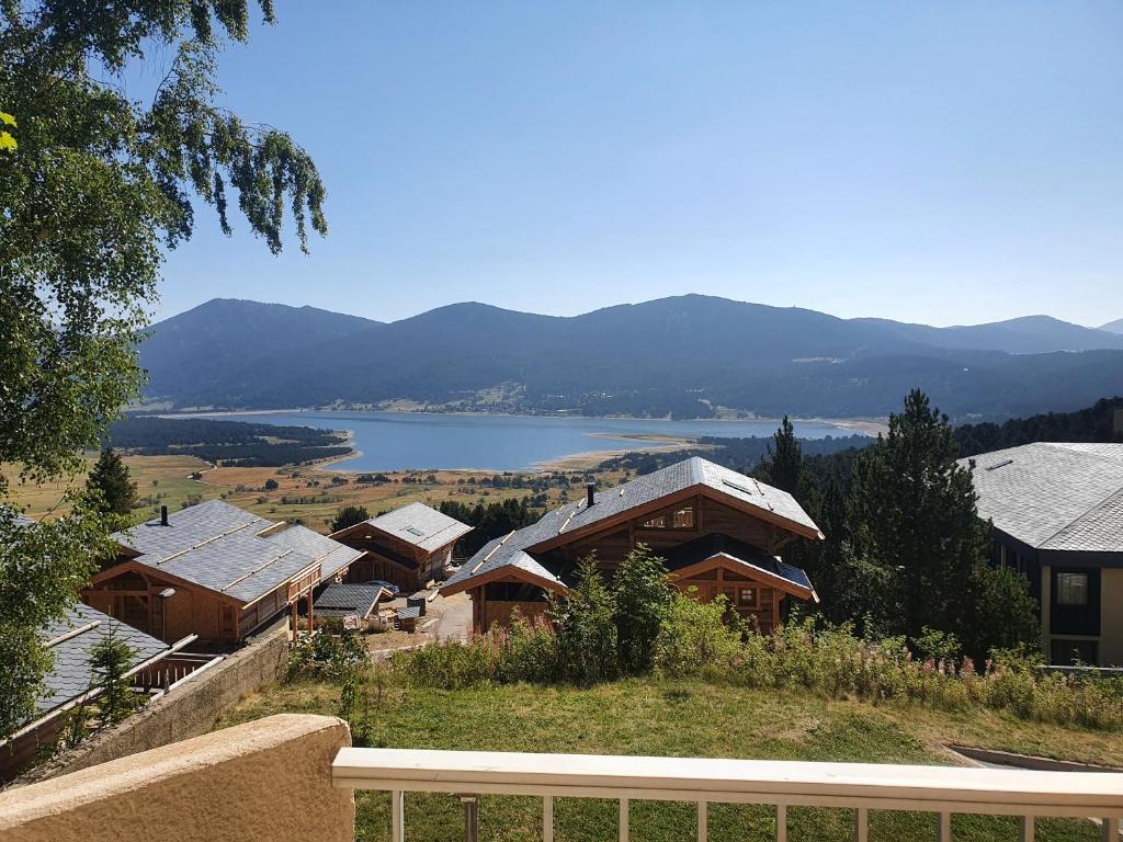 un gruppo di case con un lago sullo sfondo di Studio avec vue imprenable sur lac a Les Angles