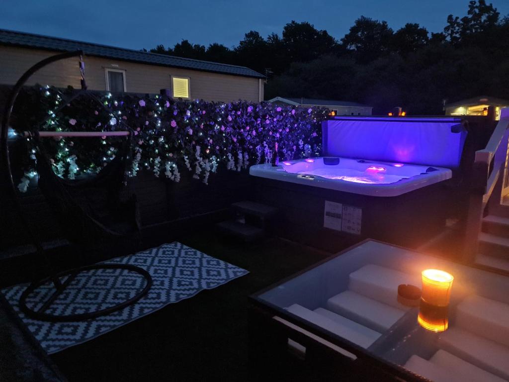 a backyard with a hot tub and lights at night at Scarletts Escape - Percy Wood in Morpeth