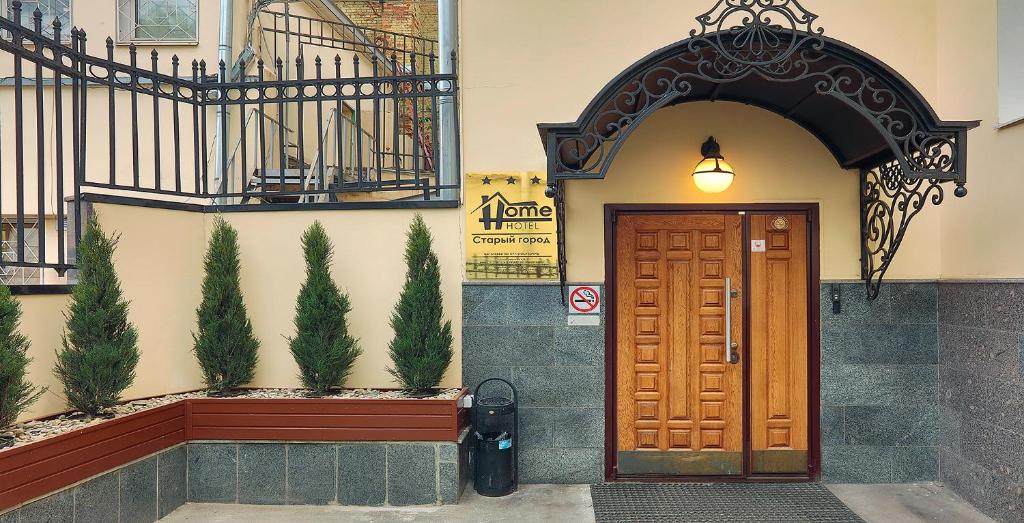 un edificio con una puerta de madera y algunas plantas en Hotel Old City by Home Hotel, en Moscú