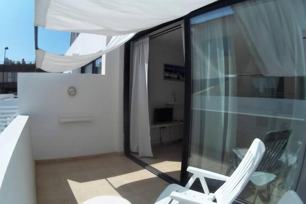 a balcony with two white chairs and a window at CasaMandy CotilloMar in Cotillo