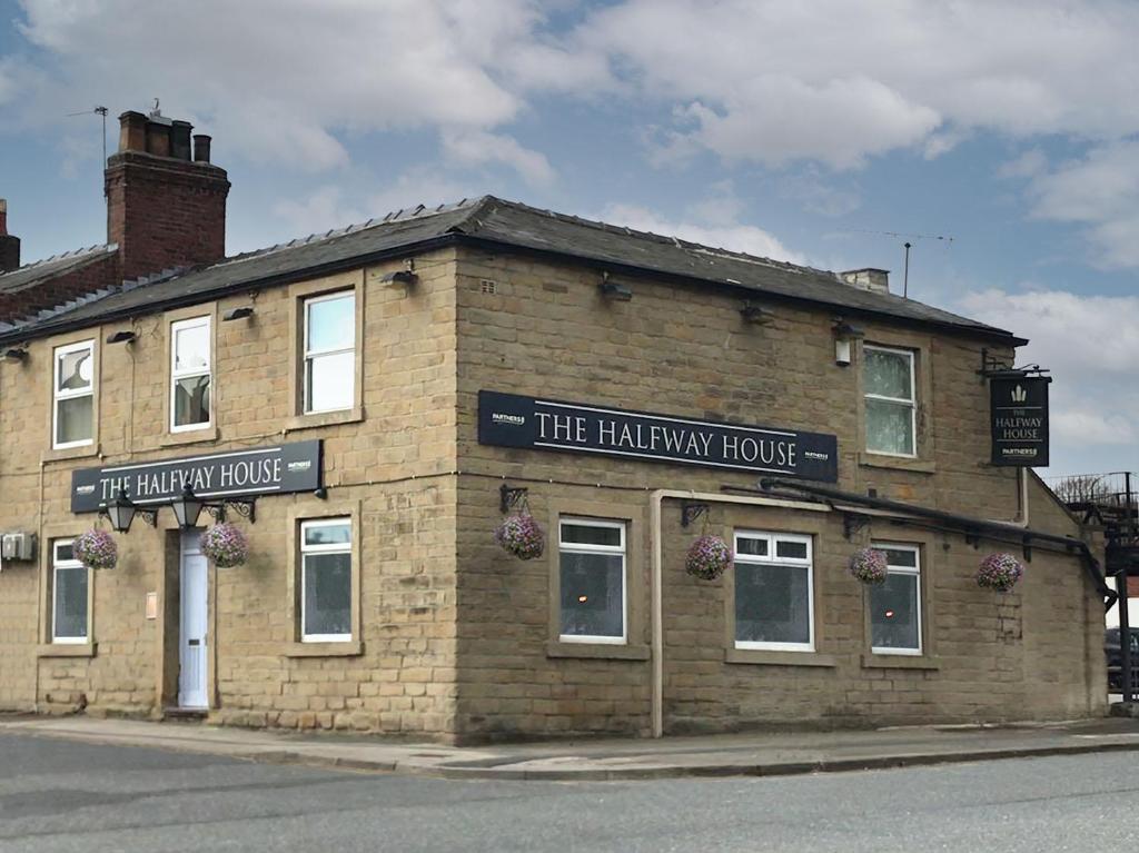 um edifício de tijolos na esquina de uma rua em The Halfway House Inn em Leeds