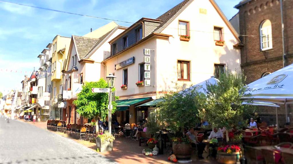 een stadsstraat met tafels, stoelen en gebouwen bij Hotel Garni Kluth in Bonn