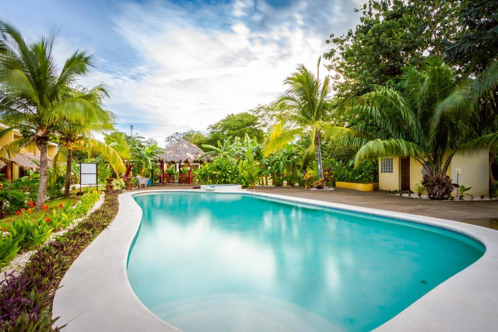 a swimming pool in a resort with palm trees at Cabo Velas Estates in Playa Grande