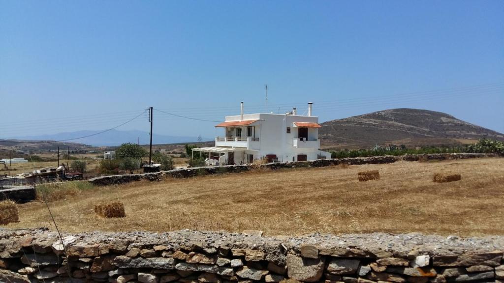 a white house on top of a hill with hay at Rhykkes Farmhouse with view in Áno Sangríon