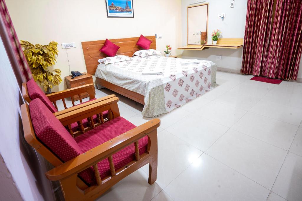 a bedroom with a bed and a chair at Hotel TamilNadu - Madurai I in Madurai