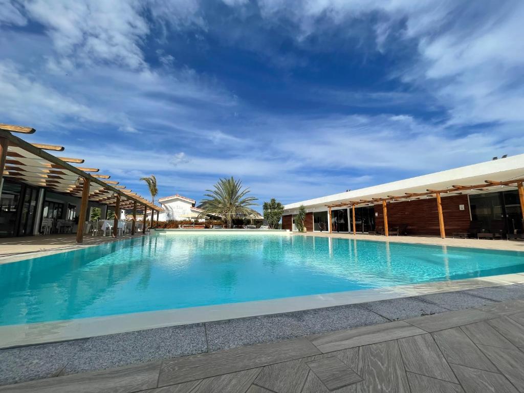 una gran piscina junto a un edificio en Sa Iba Resort en Tertenìa