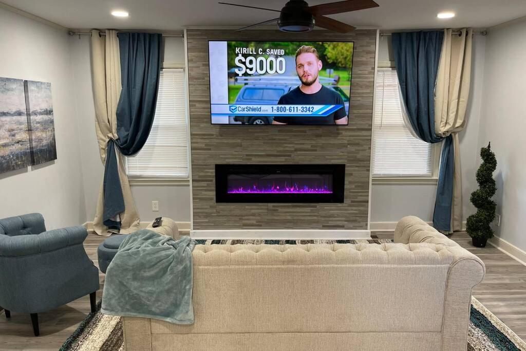 a living room with a couch and a flat screen tv at ATL XPLOR (8mins to Airport/10mins to midtown) in Atlanta