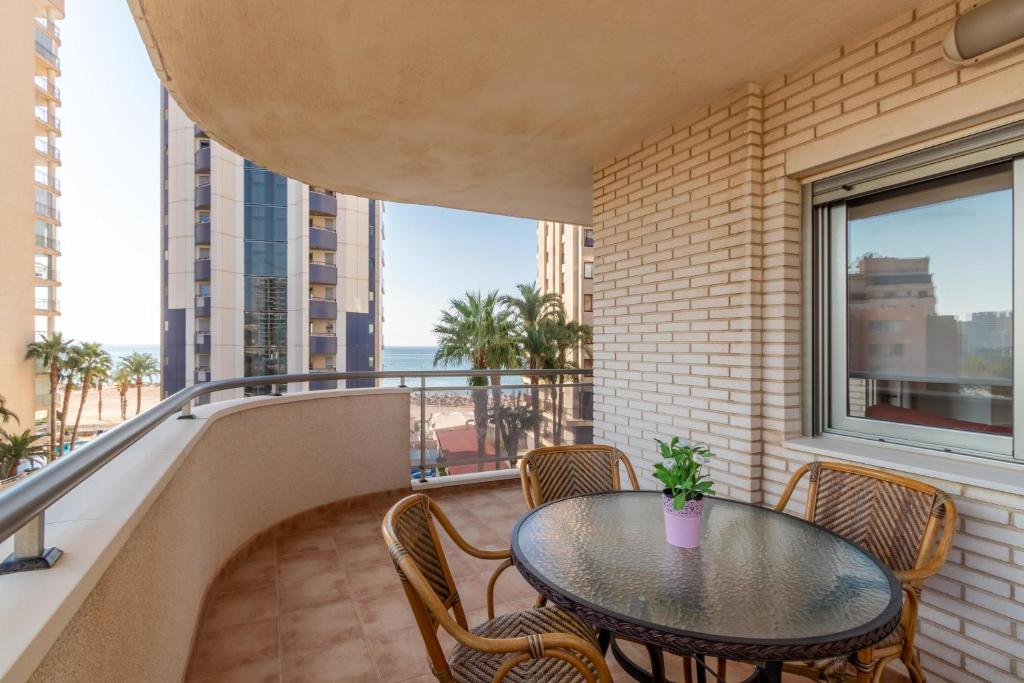 balcón con mesa, sillas y ventana en Bahia del Sol, en Calpe