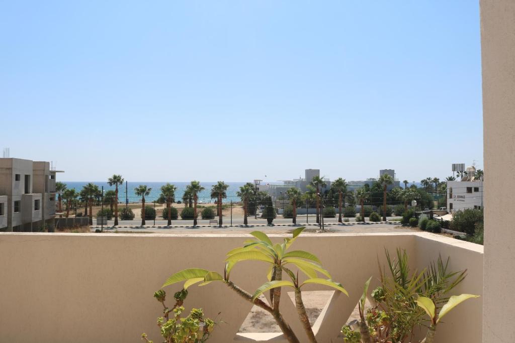 a view from the balcony of a building with palm trees at Ria Beach Sea View Apartment in Pyla