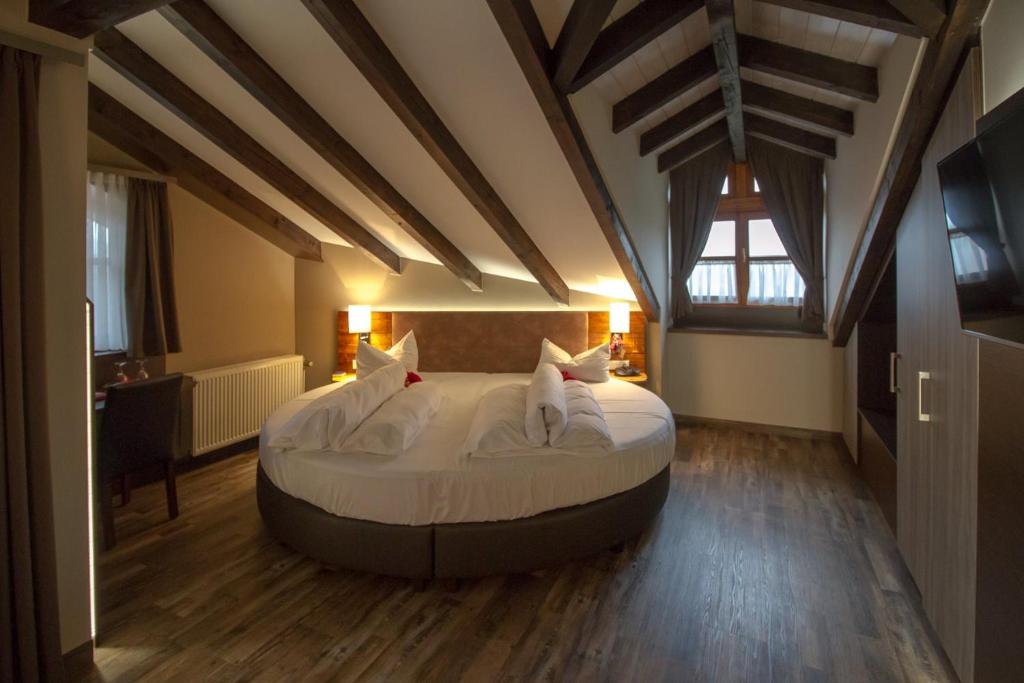 sypialnia z dużym łóżkiem na poddaszu w obiekcie Bernrieder Hof w mieście Bernried