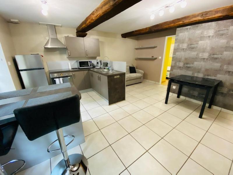 a large kitchen with a table in a room at Bel appartement cœur de ville in Chalon-sur-Saône