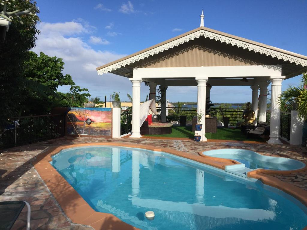 een zwembad in een tuin met een tuinhuisje bij Panorama Villa in La Gaulette