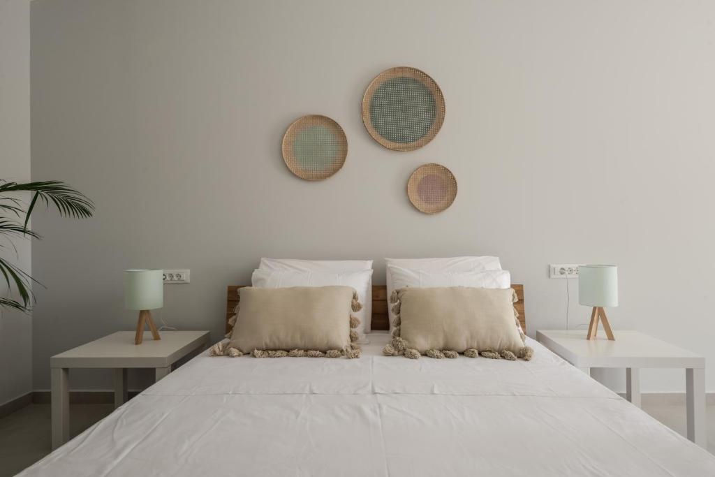 a white bedroom with a large white bed with two tables at Cabanelli in Zakynthos Town