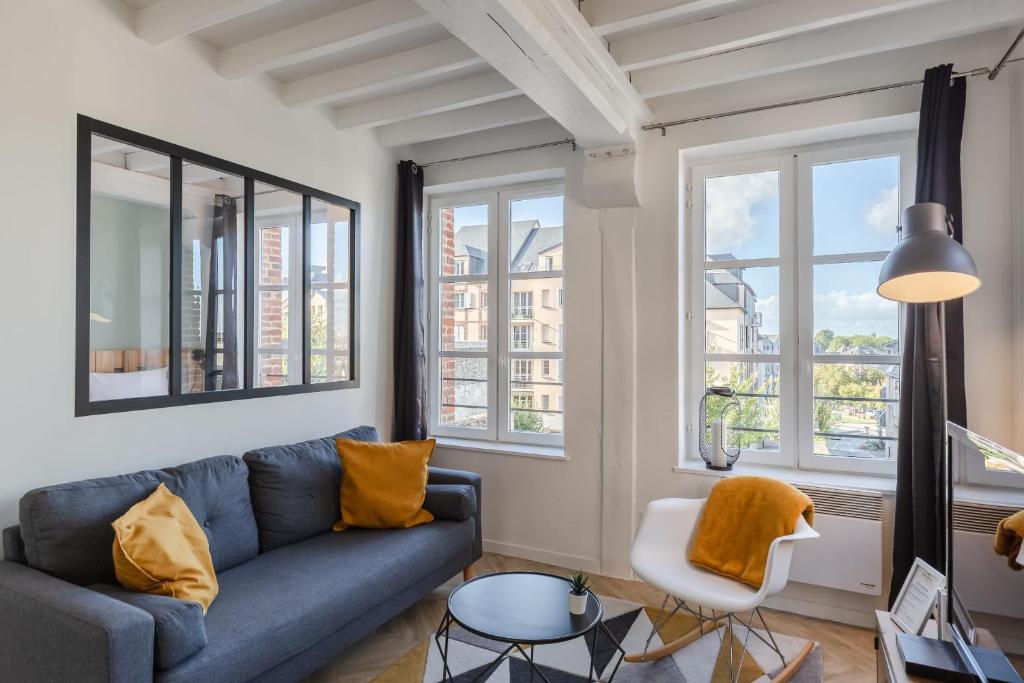 - un salon avec un canapé bleu et 2 fenêtres dans l'établissement le temps de vivre - city center - wifi, à Honfleur