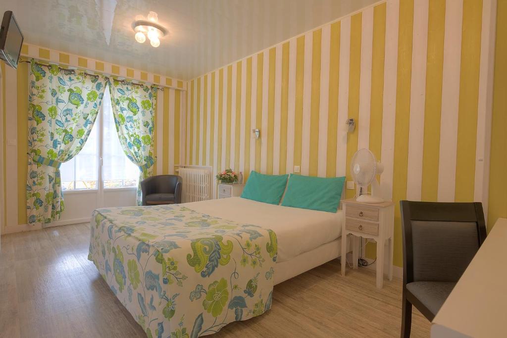 um quarto com uma cama, 2 cadeiras e uma janela em Hôtel Restaurant L'Essille Logishotel Elégance em Bassac