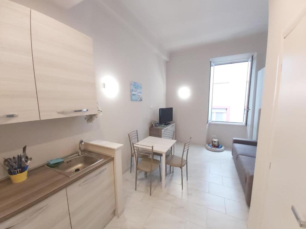 a kitchen and dining room with a table and a couch at Casa Mazzini in Alassio