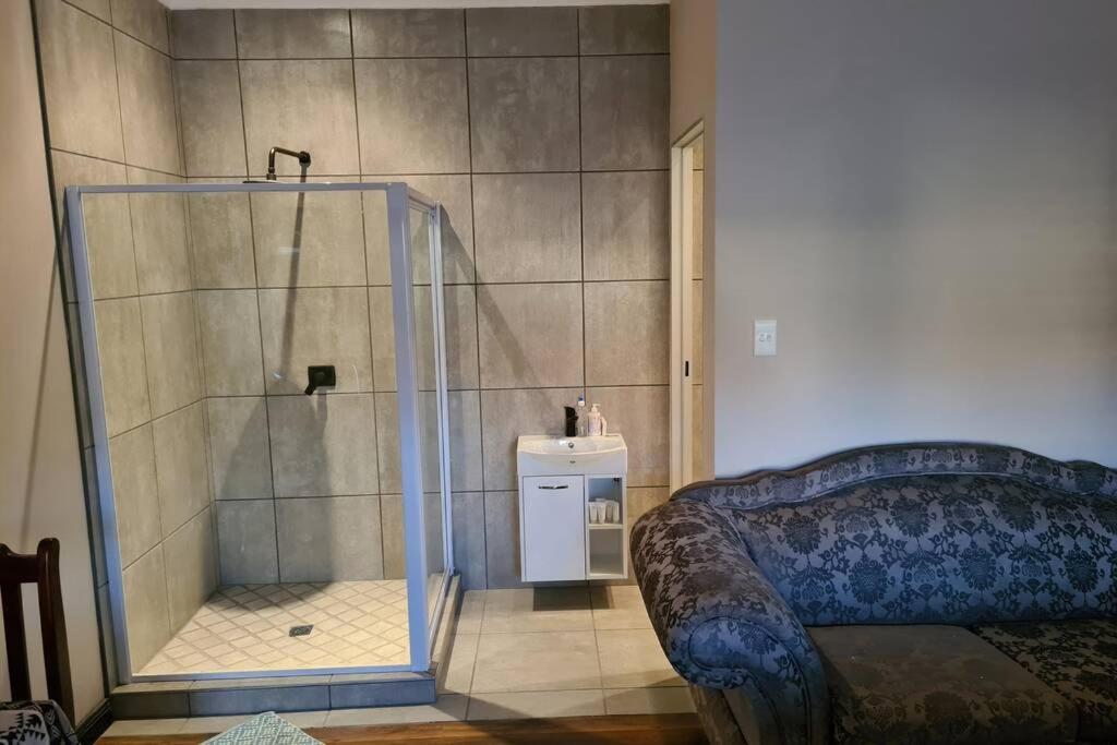 a shower with a glass door in a room at Pattys Place 12 Hakbos Street in Kathu