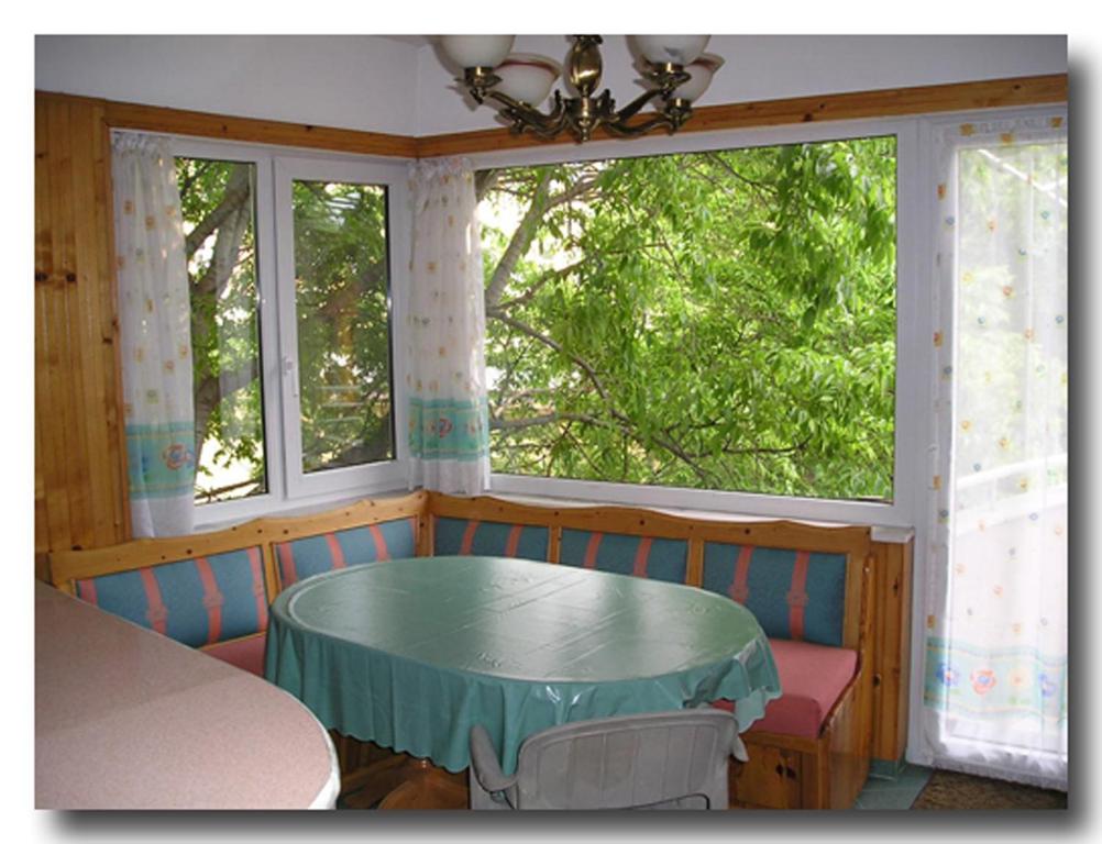 a dining room with a table and two windows at Odesos Apartments in Varna City