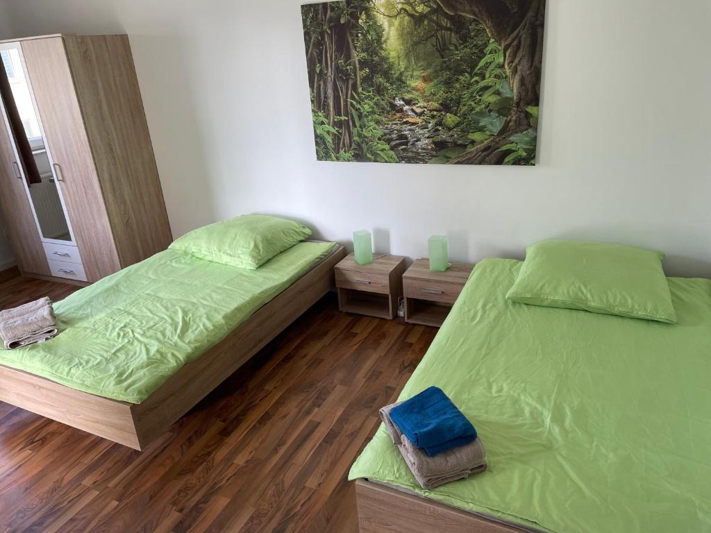 een slaapkamer met 2 bedden en een schilderij aan de muur bij Onkel Tom Amazonien & Ozeanien in Paderborn