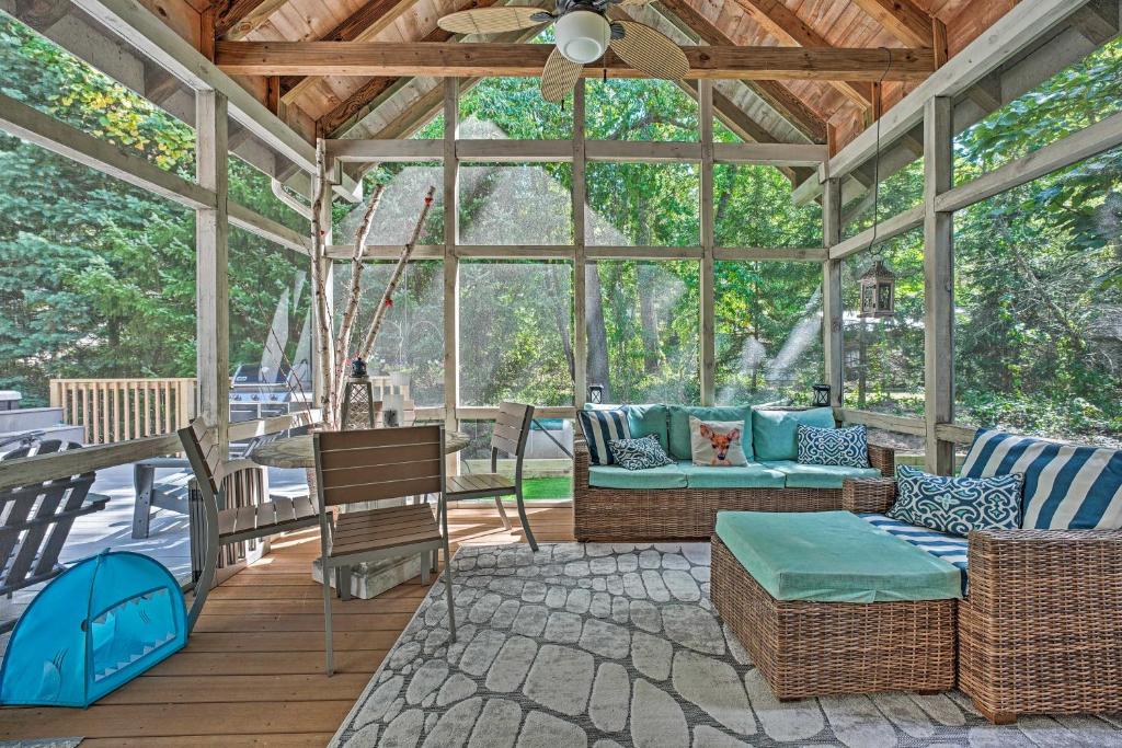 a screened in porch with wicker furniture and a ceiling at Luxury Family Home with Deck, Swim Spa and Grill! in New Buffalo