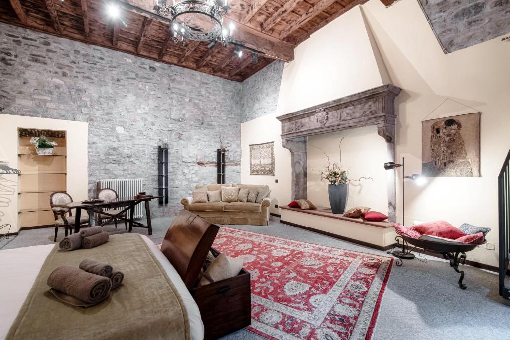 Habitación grande con pared de piedra y sala de estar. en Historical Suites - The House Of Travelers, en Como
