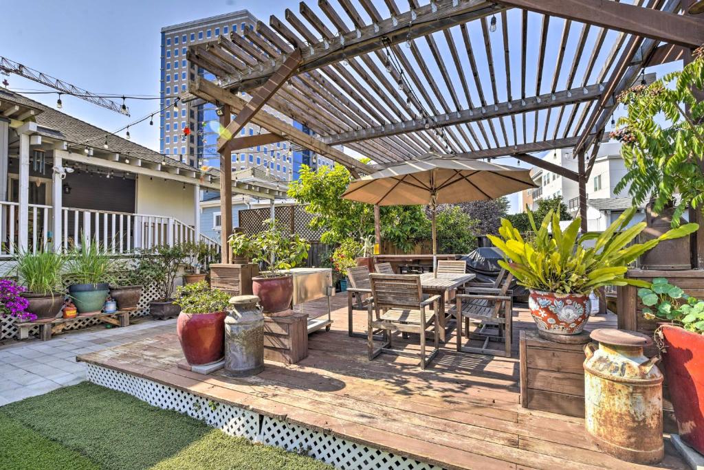 Beautiful San Jose House with Private Backyard! في سان خوسيه: سطح خشبي مع طاولة ومظلة