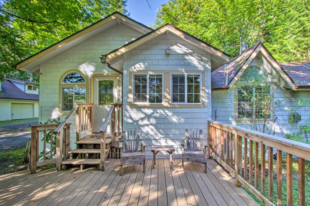 uma casa com um deque com uma mesa e cadeiras em Elk Hideaway Ashford Cottage with Hot Tub! em Ashford