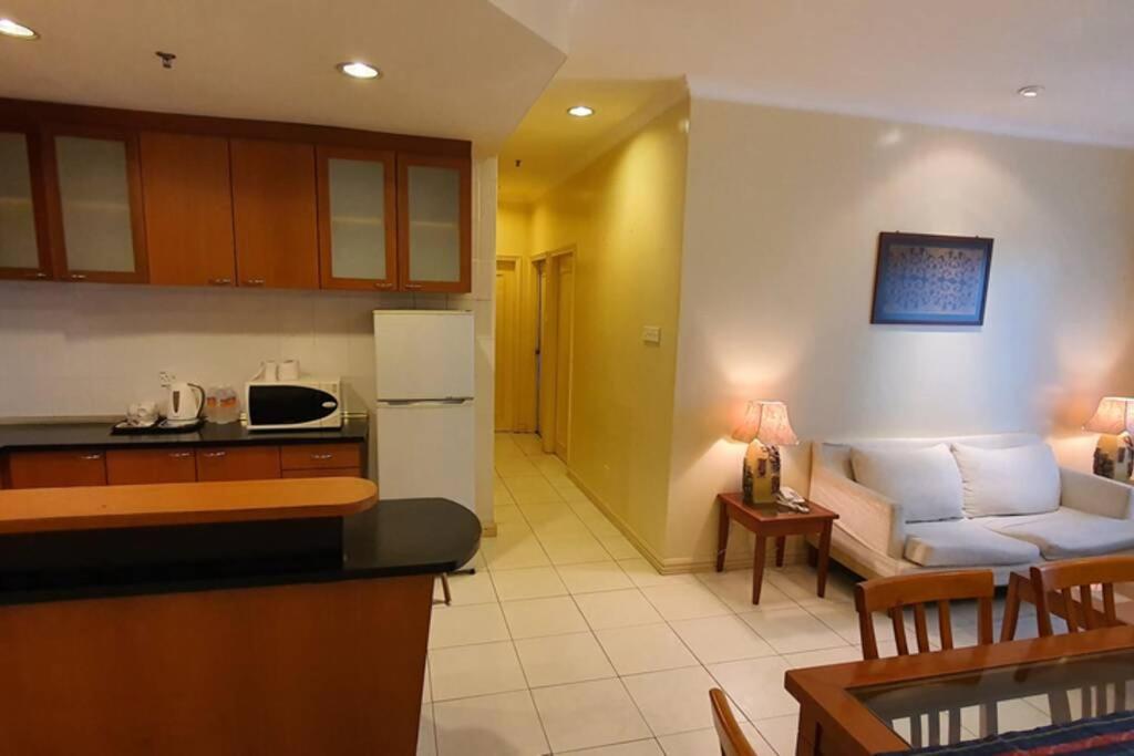 una cucina e un soggiorno con divano di Gateway Suite Cozy Dream Home for Nature Lover 8A a Kuching