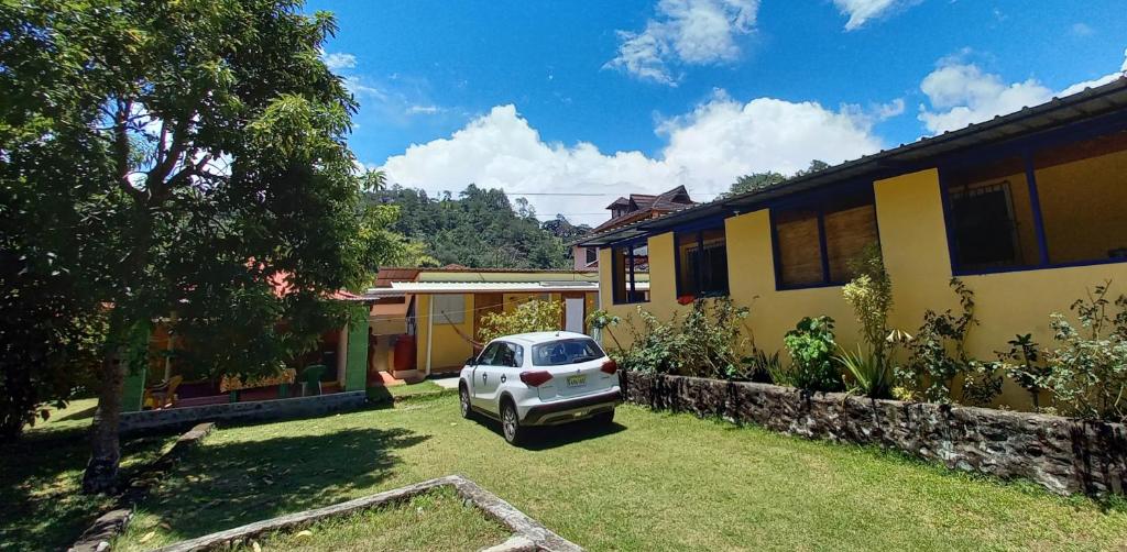 um carro estacionado num quintal ao lado de uma casa em Conrado's Guesthouse B&B em Las Avispas