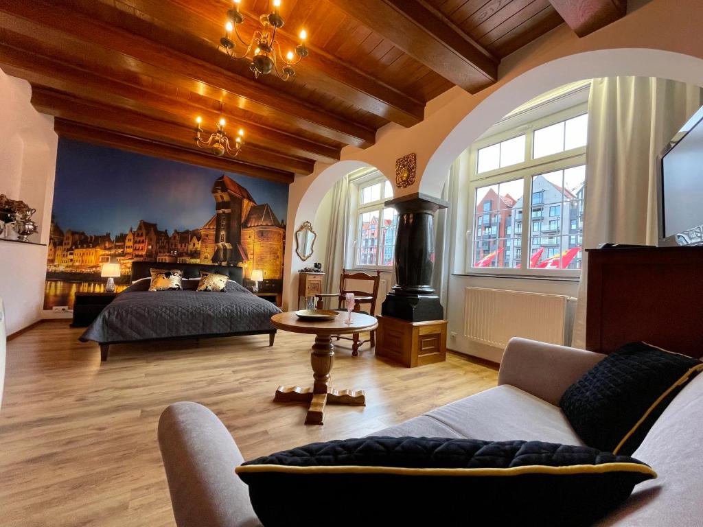 ein Schlafzimmer mit einem Bett und einem Sofa in einem Zimmer in der Unterkunft Apartamenty MICHEL Gdańsk Centrum BOUTIQUE HOTEL in Danzig
