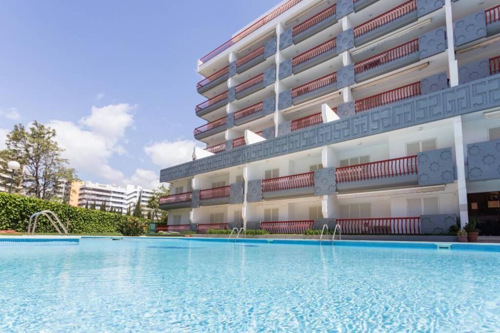 un hôtel avec une piscine devant un bâtiment dans l'établissement Tivoli Apt8 with Pool&Garage, à Vilamoura