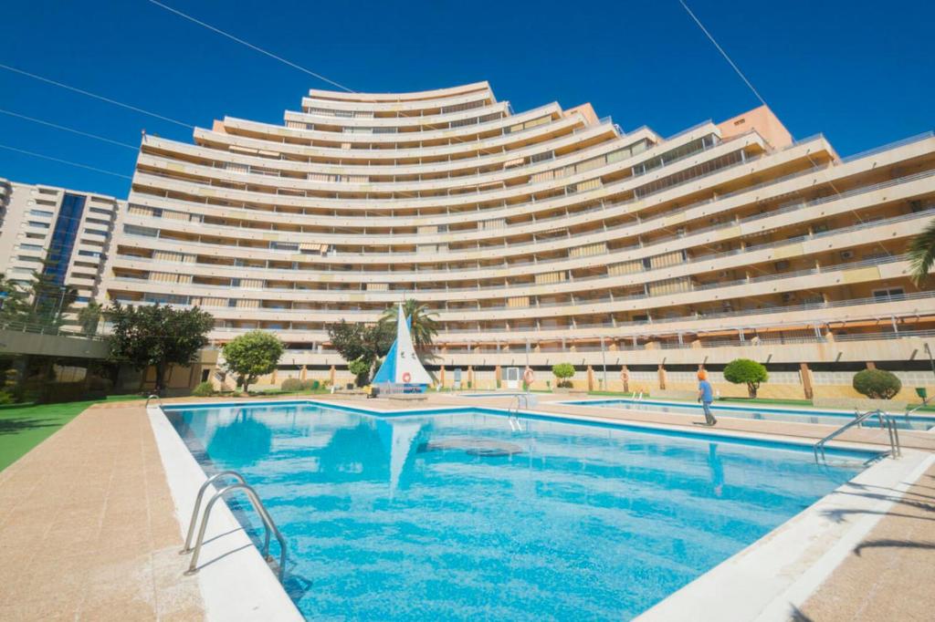 a large building with a swimming pool in front of it at Voramar 26b in Calpe