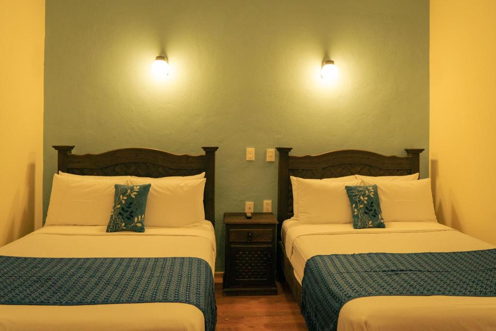 una camera d'albergo con due letti e due lampade di VO´E a San Cristóbal de Las Casas