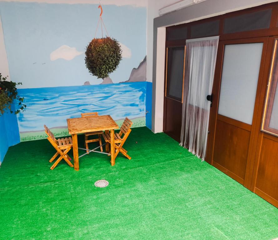 una habitación con una mesa y sillas en una alfombra verde en Bimbache Home, en La Frontera