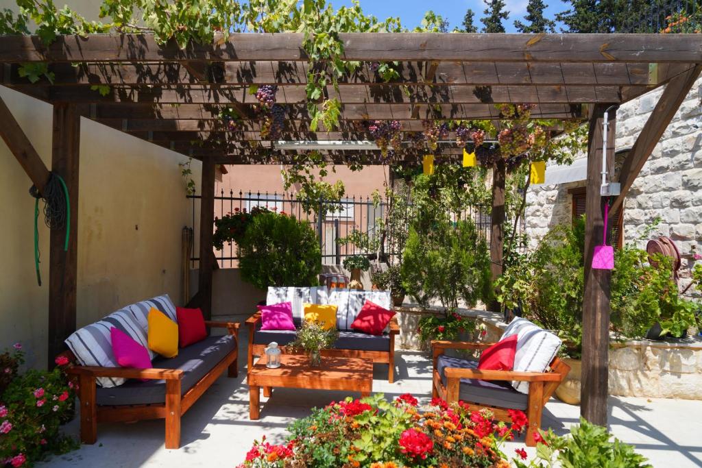 a patio with couches and a pergola with flowers at Abu Hanna Boutique by Ahlan Hospitality in Nazareth