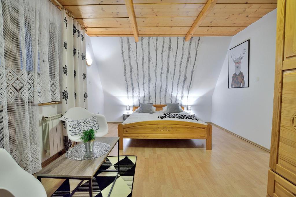 ein Schlafzimmer mit einem Bett und einem Stuhl in einem Zimmer in der Unterkunft KUROSOWY POTOK NOCLEGI ZAKOPANE CENTRUM in Zakopane
