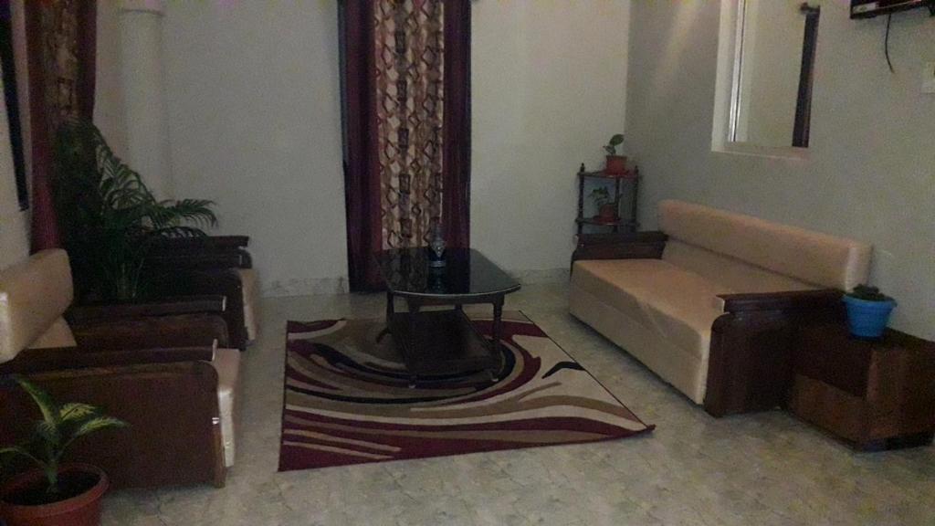 a living room with a couch and a table at Milan Palace Deoghar in Deoghar
