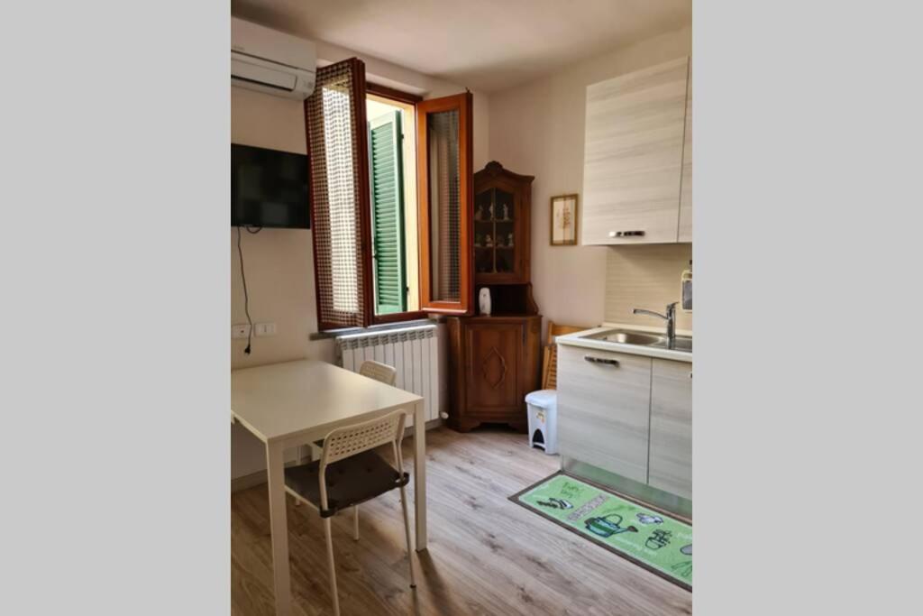 una cucina con tavolo e lavandino di Tranquillo Appartamento in piazza a Grosseto